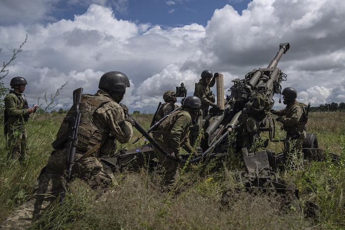 Soldados ucranianos se preparan para dispararles a posiciones rusas con un cañón M777 suministrado por Estados Unidos, el 14 de julio de 2022, en la región de Járkiv, Ucrania.