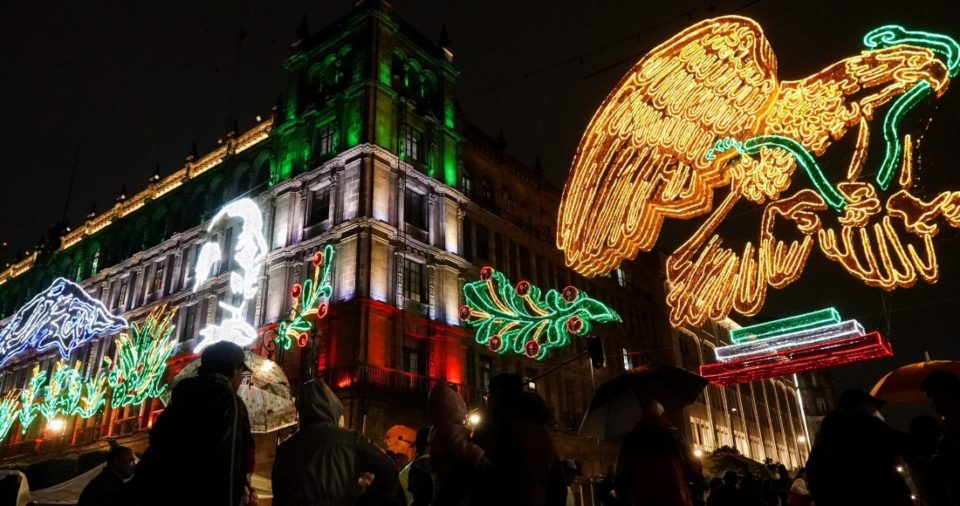 Visitantes aprovechan el encendido de la luminaria con motivo de las fiestas patrias en el Zócalo capitalino para tomarse selfies.