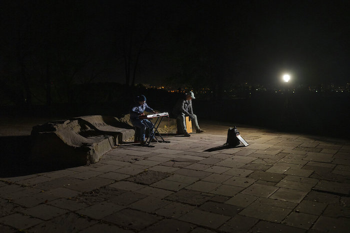 Músicos callejeros tocan instrumentos en una plaza sin luz eléctrica en Kiev, Ucrania, el martes 18 de octubre de 2022.