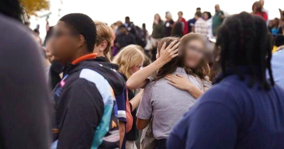 Unas personas se reúnen afuera de una escuela secundaria de San Luis, Missouri, luego de que se registró un tiroteo, el lunes 24 de octubre de 2022.