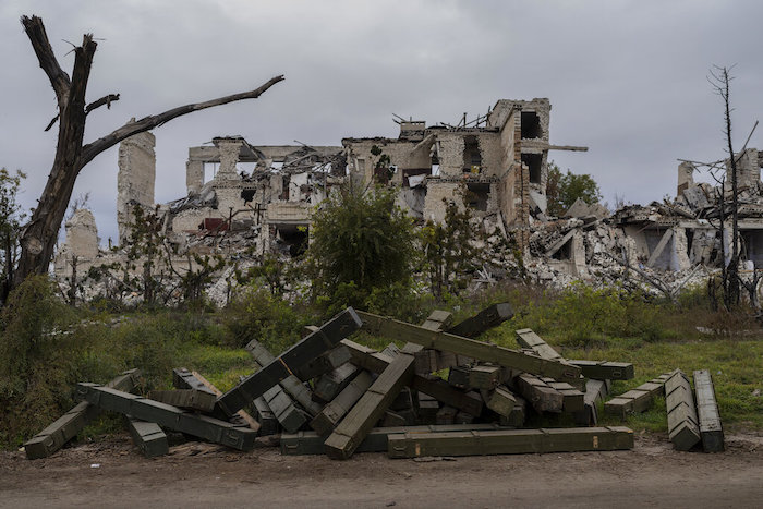 Cajas de municiones están afuera de una escuela destruida en una aldea recientemente liberada en las afueras de Jersón, en el sur de Ucrania, el miércoles 16 de noviembre de 2022.