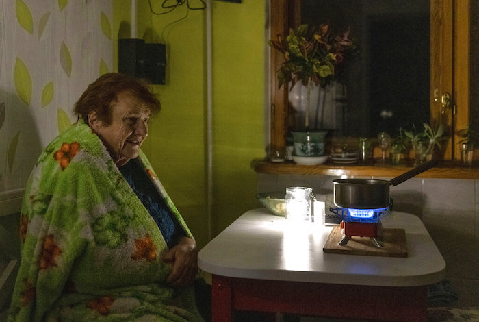 Una anciana cocina durante un apagón en Kiev, Ucrania, el lunes 14 de noviembre de 2022.