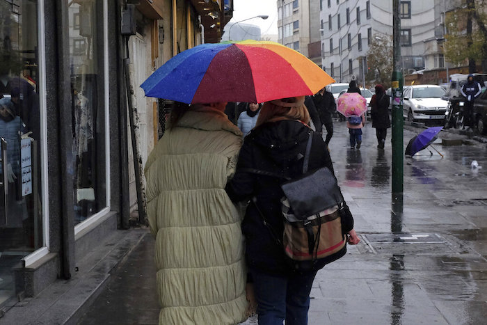 Dos mujeres se protegen de la lluvia mientras caminan en el Bazar del barrio de Tajrish, en el norte de Teherán, Irán, el lunes 5 de diciembre de 2022.
