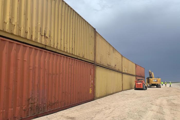 Esta fotografía proporcionada por la oficina del Gobernador de Arizona muestra contenedores de carga que serán utilizados para cubrir un tramo inconcluso de 304 metros (mil) pies en el muro fronterizo con México, el 12 de agosto de 2022, cerca de Yuma, Arizona.