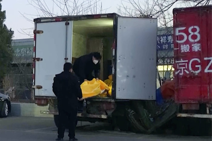 Operarios cargan bolsas para cadáveres en un camión en un complejo funerario en Beijing, el 16 de diciembre de 2022.