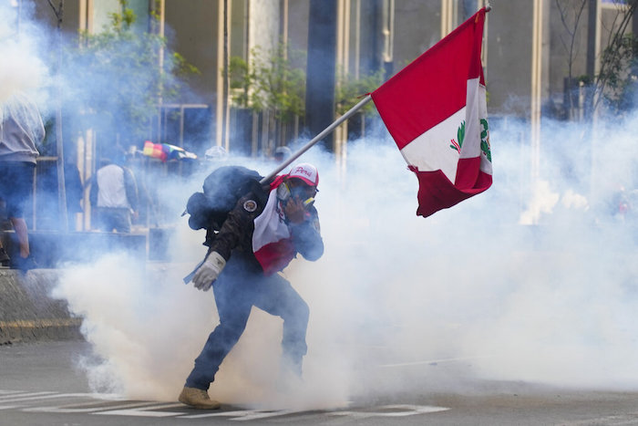 Un simpatizante del destituido Presidente Pedro Castillo devuelve un contenedor de gas lacrimógeno en dirección a la policía, el lunes 12 de diciembre de 2022, en Lima, Perú.