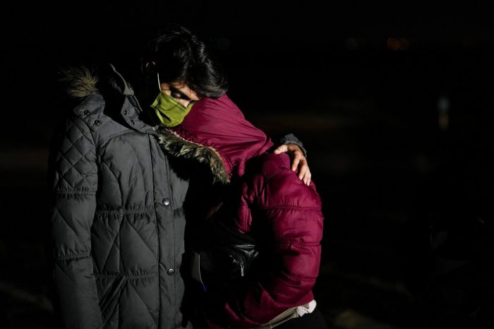 El migrante cubano Mario Pérez abraza a su esposa mientras esperan solicitar asilo luego de cruzar la frontera a Estados Unidos, el viernes 6 de enero de 2023, cerca de Yuma, Arizona.