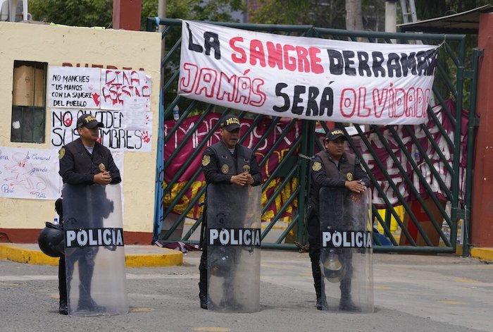 Policías antimotines hacen guardia a la entrada de la universidad de San Marcos que alberga a las personas que viajaron a la capital peruana desde otras partes del país para unirse a las protestas contra el Gobierno de la Presidenta peruana Dina Boluarte y el Congreso en Lima, Perú, el viernes 20 de enero de 2023.