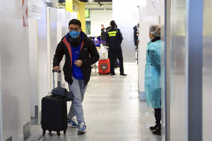 Un pasajero procedente de China camina luego de someterse a una prueba de COVID-19 en el aeropuerto Roissy Charles de Gaulle, al norte de París, el domingo 1 de enero de 2023. 