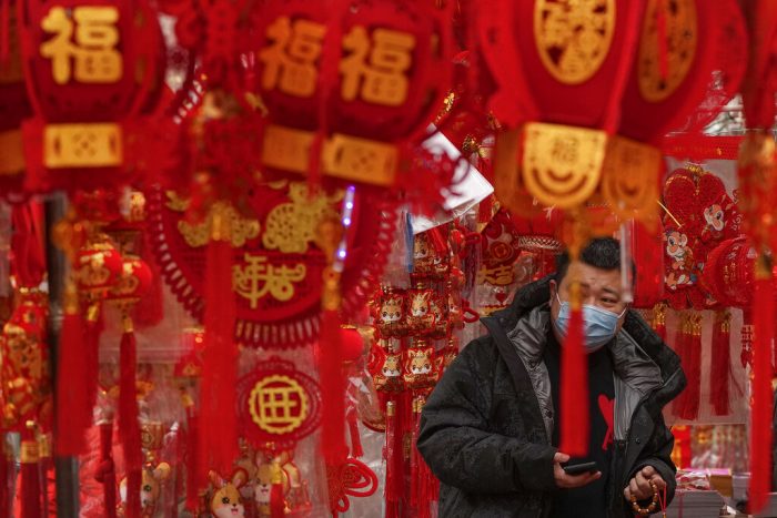 Un hombre, con mascarilla para protegerse del coronavirus, compra decoraciones para el Año Nuevo Lunar en un puesto en Beijing, el 7 de enero de 2023.