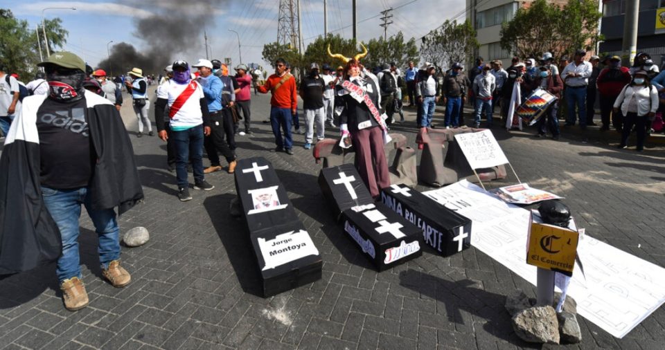 Manifestantes bloquean una carretera con réplicas de ataúdes que llevan los nombres de la Presidenta peruana Dina Boluarte y congresistas en Arequipa, Perú, el jueves 19 de enero de 2023.