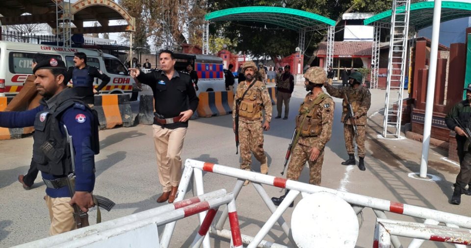 Soldados y policías despejan el acceso para ambulancias al lugar donde explotó una bomba, en una entrada a oficinas policiales en Peshawar, Pakistán, el lunes 30 de enero de 2023.