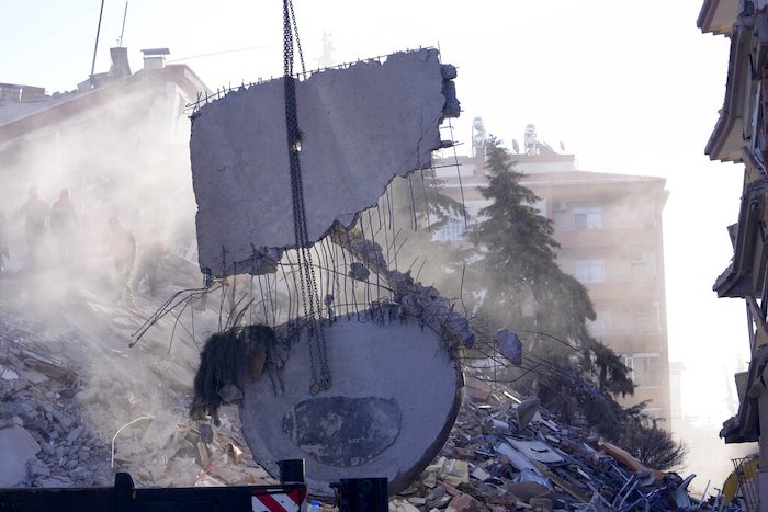 Una grúa retira escombros al tiempo que los rescatistas buscan sobrevivientes en un edificio destruido en Gaziantep, en el sureste de Turquía, el jueves 9 de febrero de 2023.