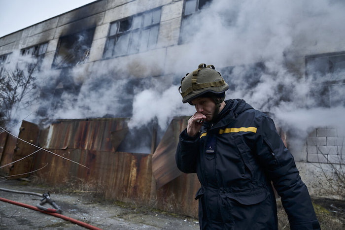 Un bombero ucraniano fuma durante un descanso luego de un ataque ruso contra una zona industrial, el domingo 5 de febrero de 2023, en Jersón, Ucrania.