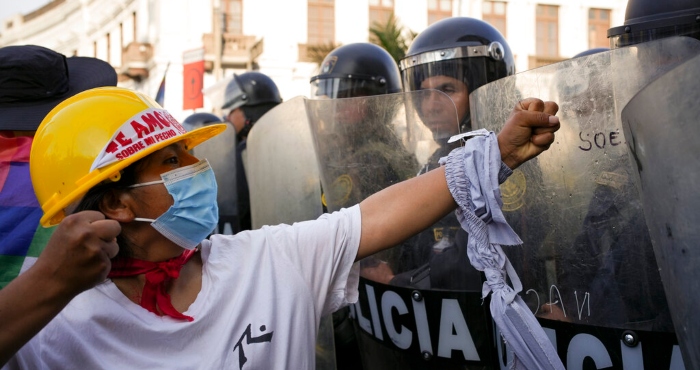 Un manifestante de oposición al gobierno encara a una línea de policías antimotines en Lima, Perú, el jueves 26 de enero de 2023. 