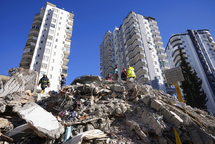 Equipos de emergencias buscan a personas entre los escombros de un edificio destruido en Adana, en el sur de Turquía, el martes 7 de febrero de 2023.
