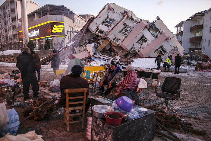 Un grupo de personas, junto a edificios que se vinieron abajo por un potente sismo en Golbasi, en la provincia de Adiyaman, Turquía, el 8 de febrero de 2023.