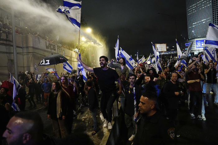 La policía israelí usa un cañón hidrante para dispersar a los manifestantes que bloquean una autopista como protesta contra el plan del Primer Ministro Benjamin Netanyahu de reformar el sistema judicial, en Tel Aviv, Israel, 25 de marzo de 2023. 