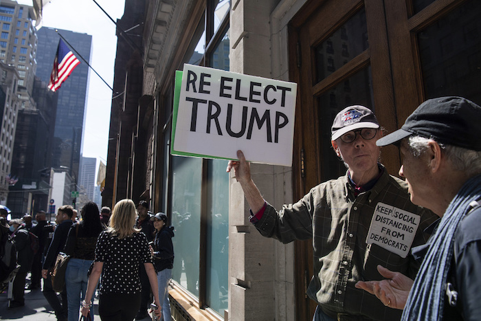 Un partidario del expresidente Donald Trump, Fred Williams, de 79 años, alza un cartel que dice "reelegir a Trump", en Manhattan, martes 4 de abril de 2023.