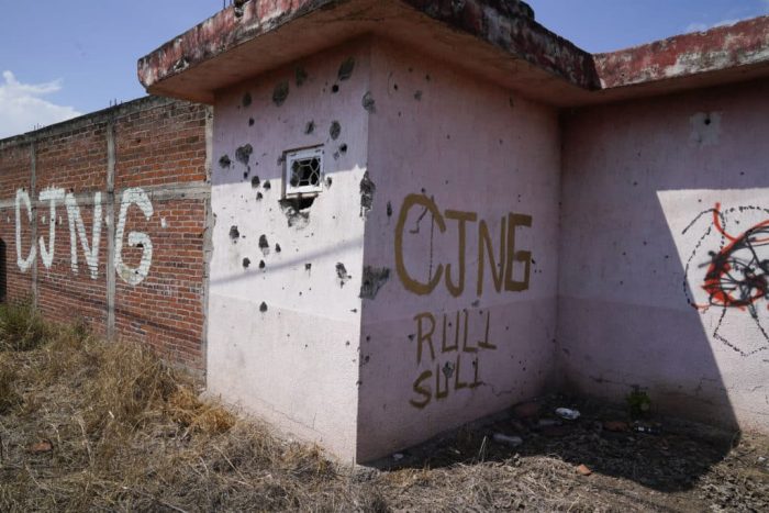 Las letras "CJNG" como abreviatura del Cártel Jalisco Nueva Generación garabateadas en la fachada de una casa abandonada en El Limoncito, en el estado de Michoacán, México.