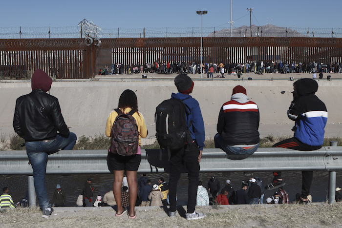 Varios migrantes observan a otros junto a la valla fronteriza en Ciudad Juárez, México, el 21 de diciembre de 2022, al otro lado de El Paso, Texas.