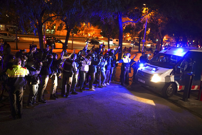 Reporteros toman foto de una camioneta de la policía que estaría trasladando al futbolista brasileño Dani Alves tras comparecer ante un juzgado de Barcelona, el viernes 20 de enero de 2023.
