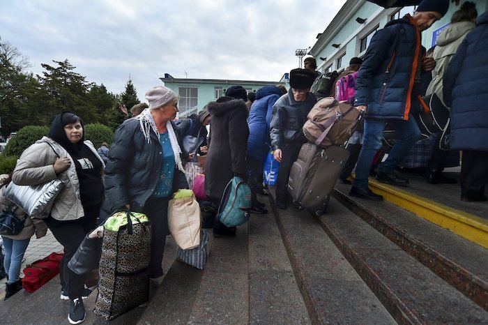 Residentes evacuados de Jersón avanzan luego de llegar a la estación de tren en Dzhankoi, Crimea, el viernes 21 de octubre de 2022.